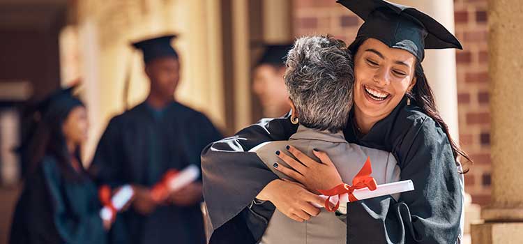 woman hugs female family member after earning college degree