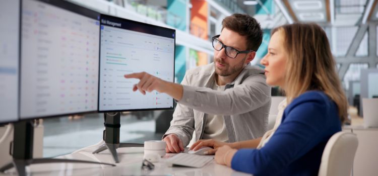 an ai security solution specialist reviews ai systems on a computer with a coworker